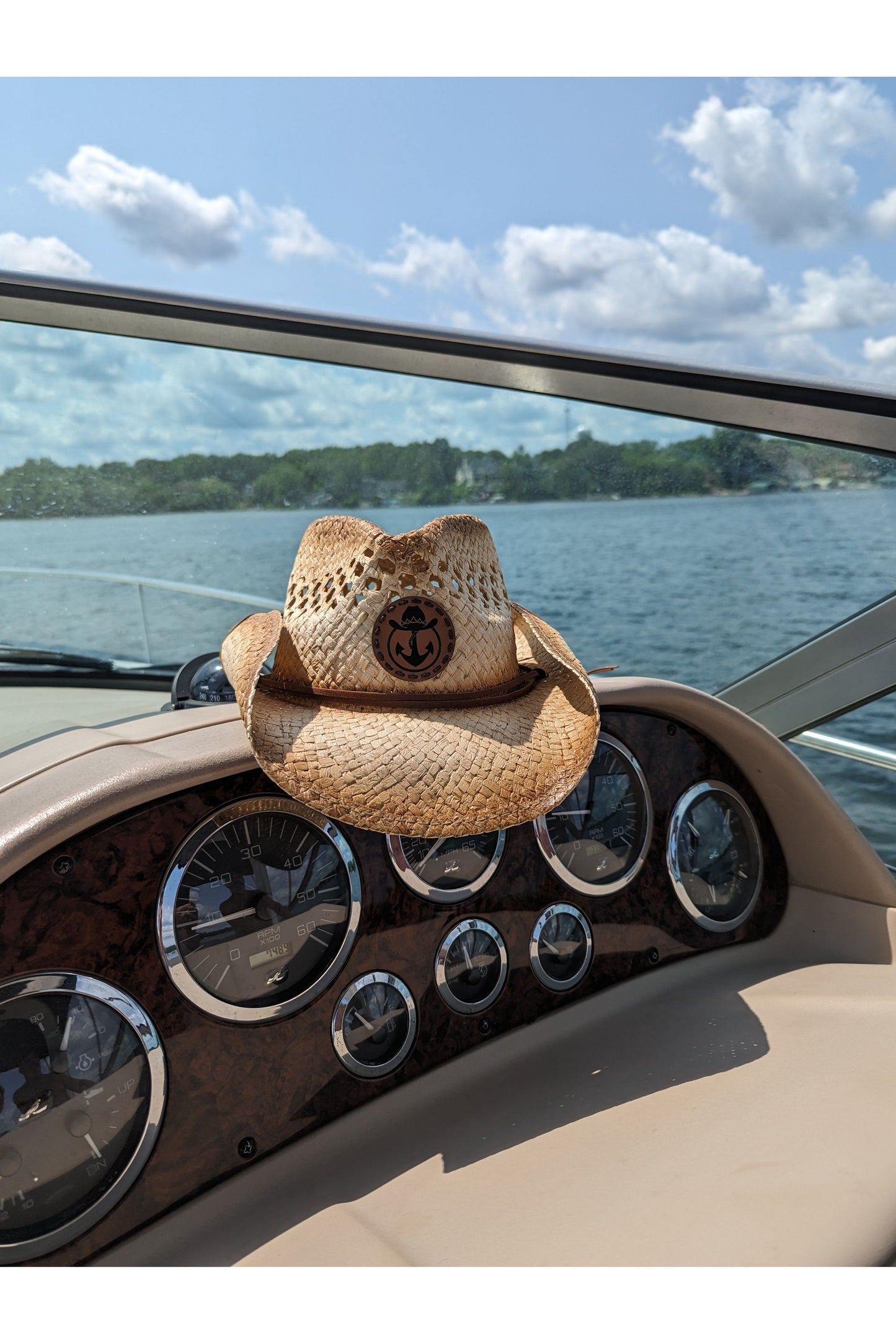 Photo of a Lake Cowboy Signature Cowboy Hat sitting atop a boat console on a sunny day on Lake Minnetonka.