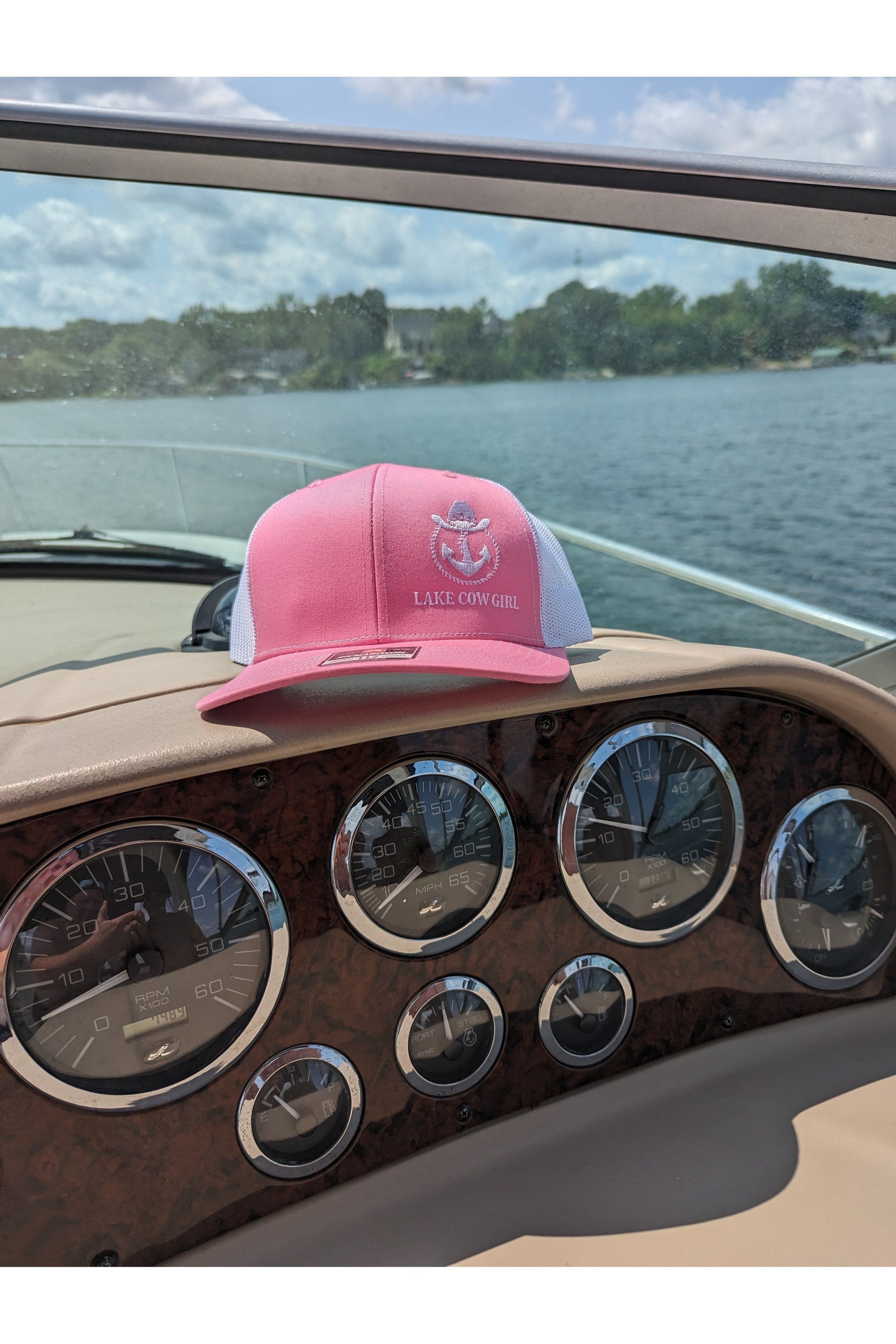 Photo of a Lake Cowgirl Pink Baseball Hat shown sitting atop a boat console. Photo taken on Lake Minnetonka.