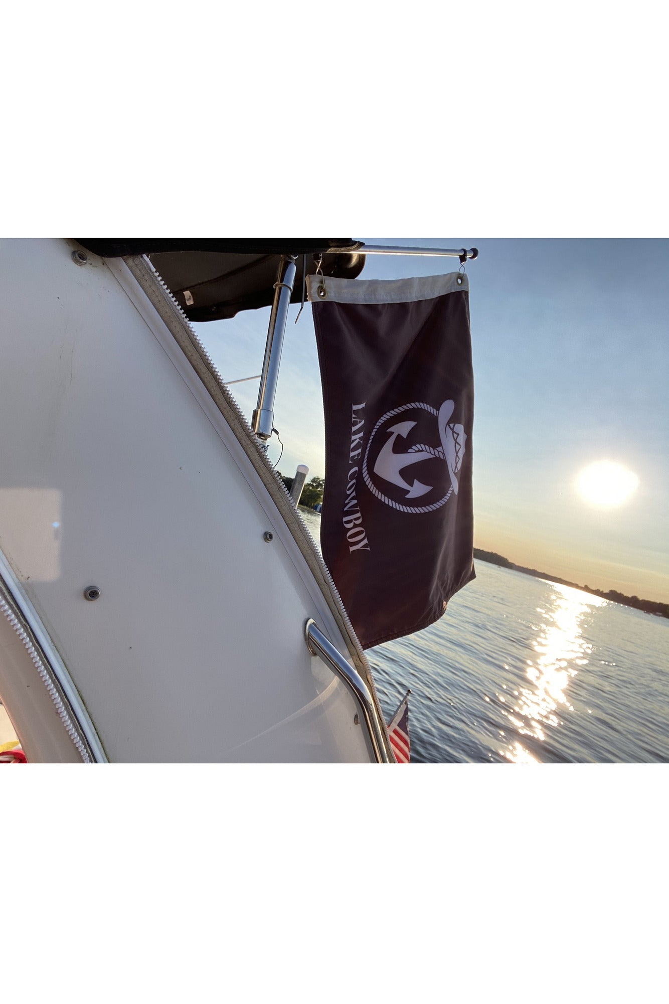 Photo of Lake Cowboy Boat Flag (Black) hanging from the stanchion of a boat