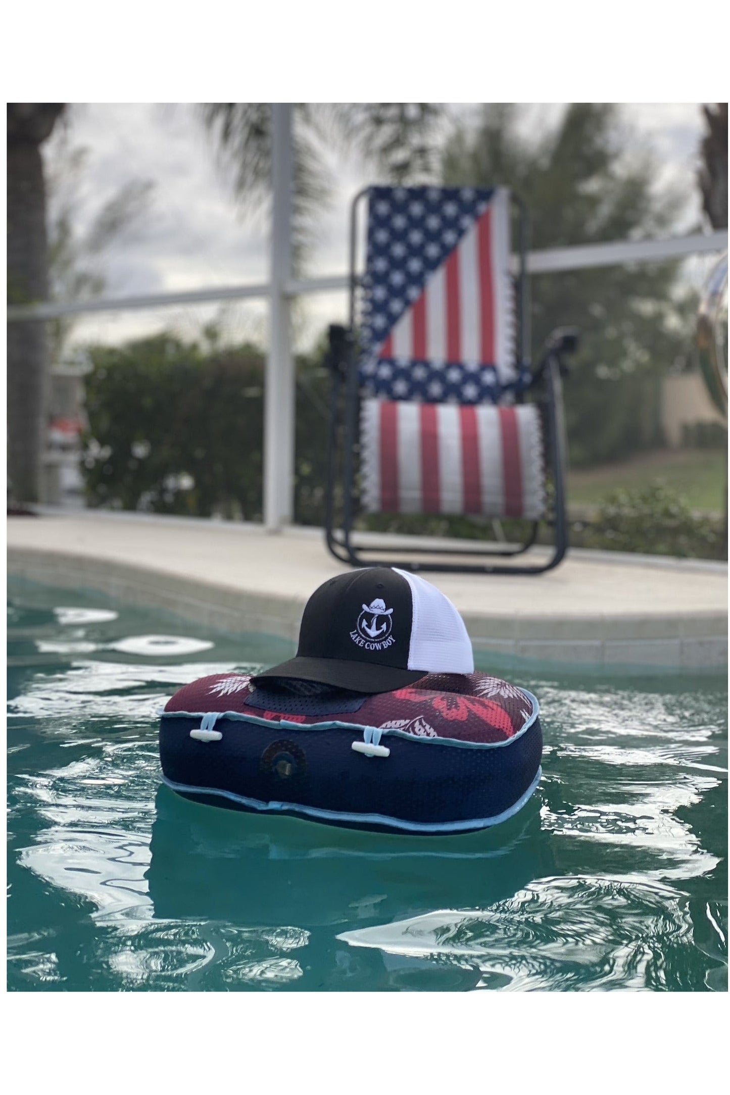 Photo of a Lake Cowboy Baseball Hat (Black & White) floating on a float in a pool in Florida