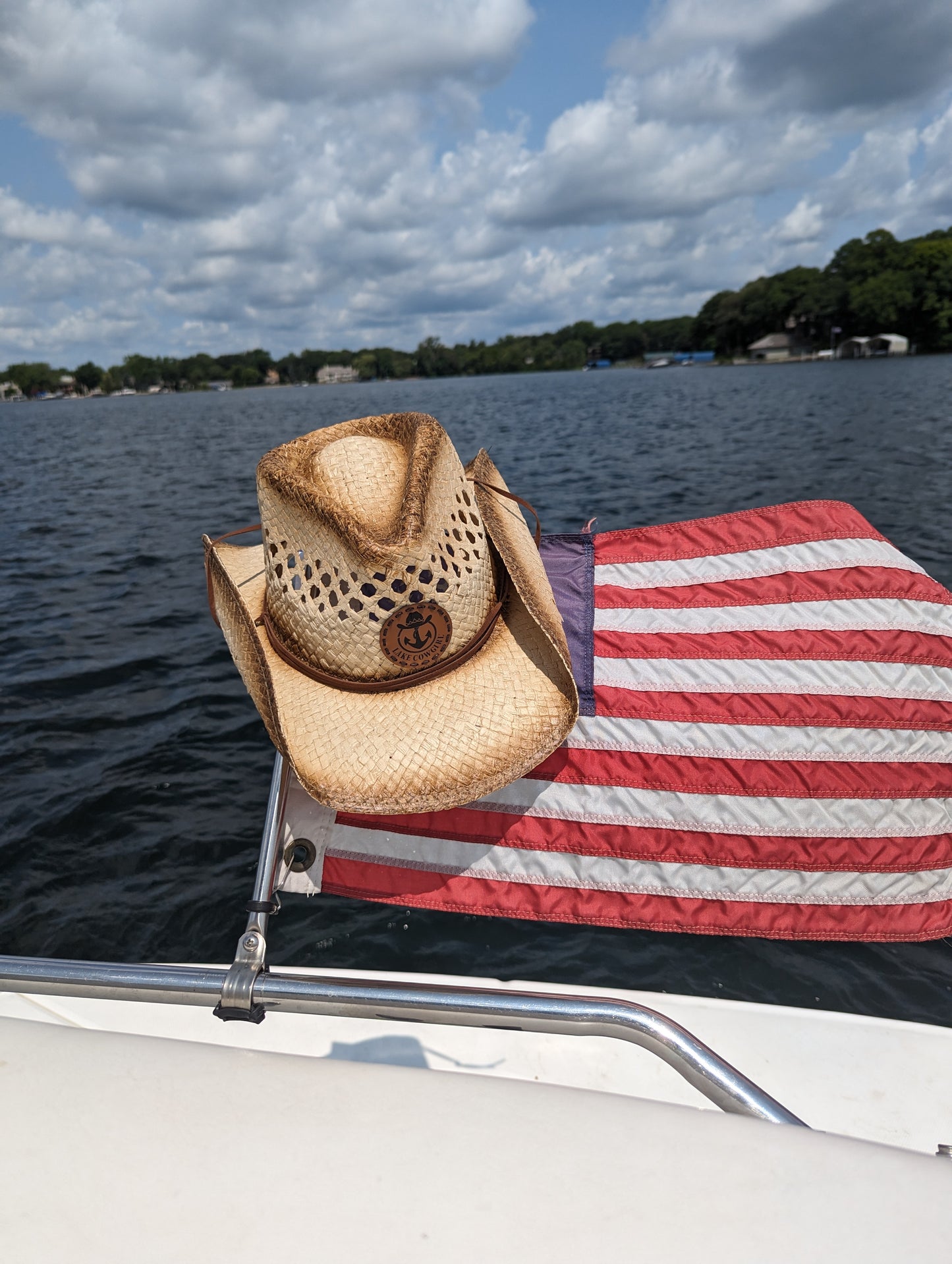 Photo of the Lake Cowgirl Signature Cowboy Hat shown sitting atop the boat flag on the back of a Sea Ray boat. Photo was taken on Lake Minnetonka.