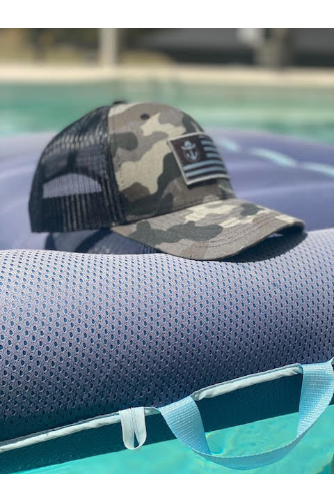 Photo of a Lake Cowboy Camo Baseball Hat (with Patriot Flag) on an air mattress in a pool in Florida